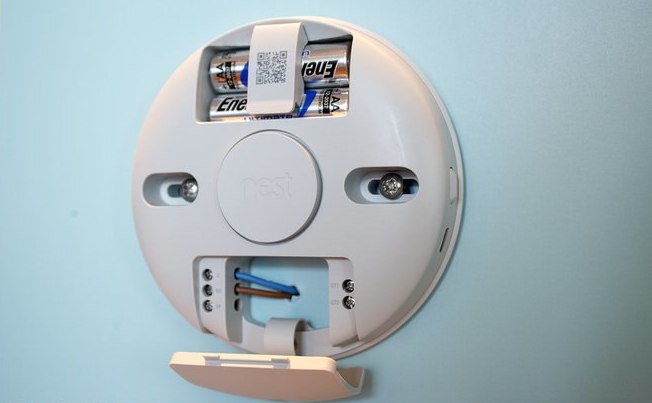 Rear of a Nest Thermostat E showing the stand clip, two AA cells, and a two-wire connection